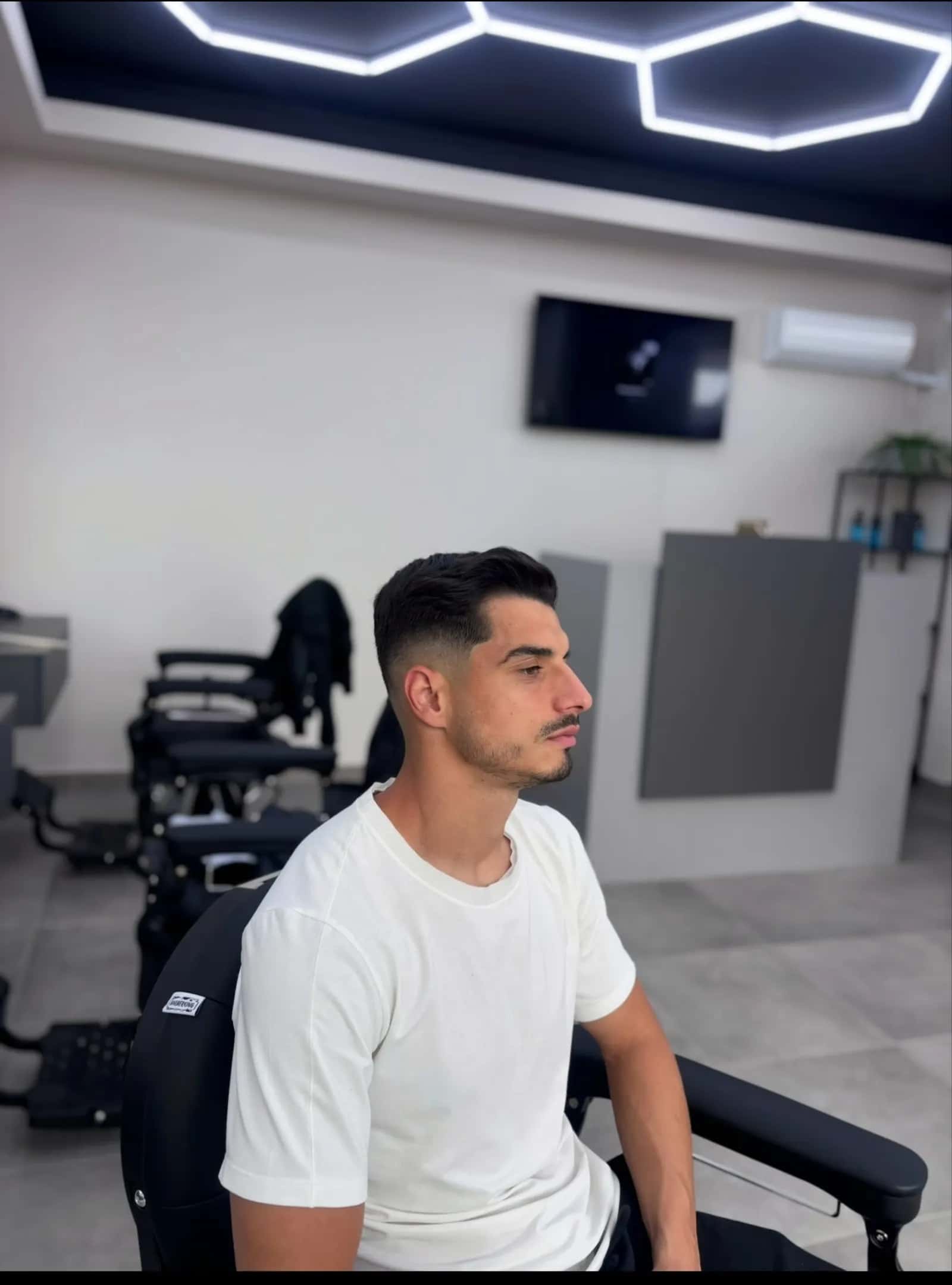 Fade proaspăt făcut la R|B Barbershop, cu tavanul în fagure în fundal